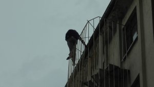 Yangın merdivenine tırmanan şahıs kafasında kırdığı kiremitleri itfaiye ekiplerine fırlattı